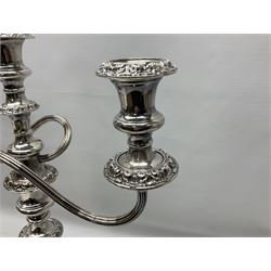 Pair of silver-plated twin branch candelabras, the foliate decorated urn-shaped nozzles raised upon reeded swept branches supported from tapering central stem, with weighted circular stepped bases, H48cm