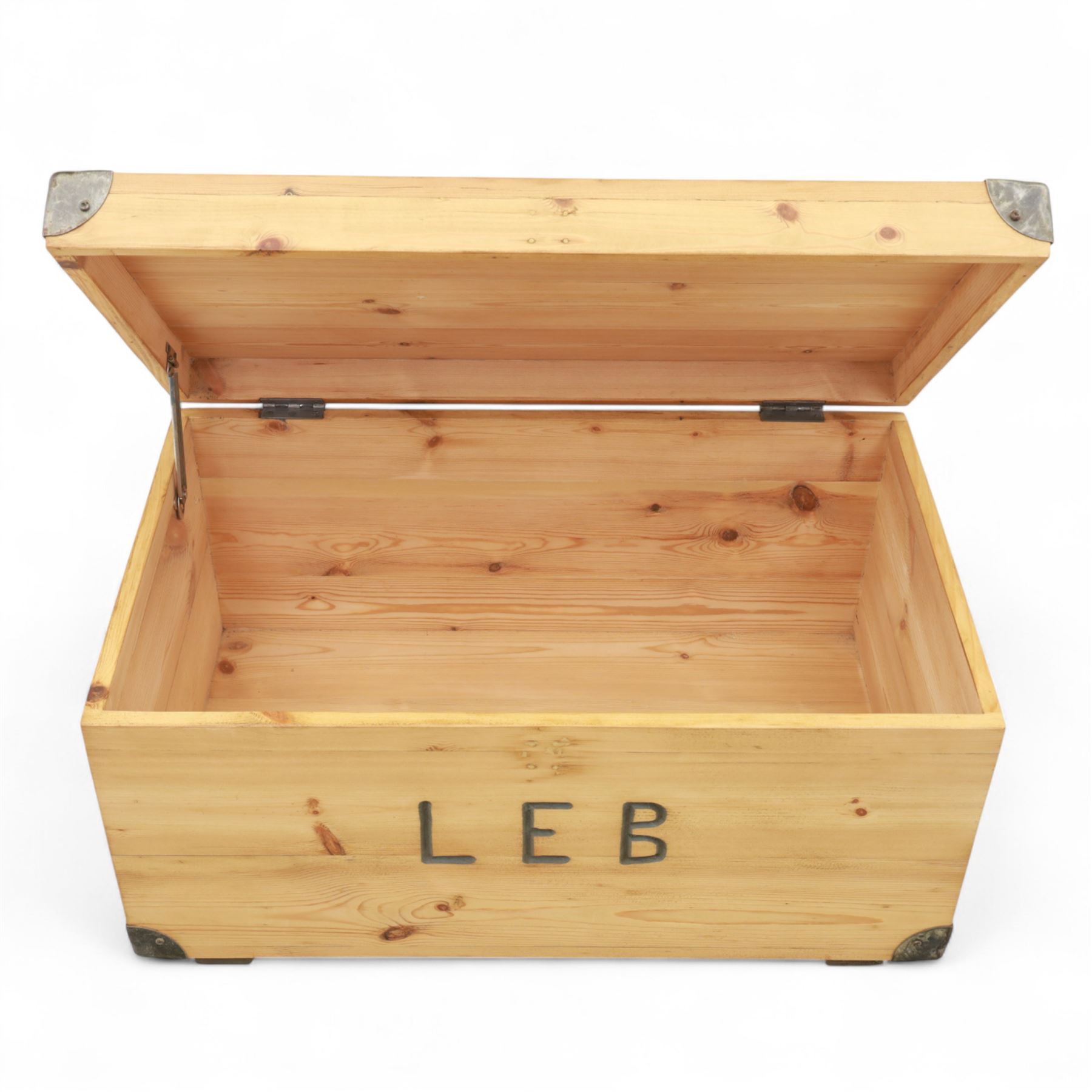 Pine storage trunk, of rectangular plank construction with metal corner protectors and stencilled lettering ‘LEB’ to front and lid