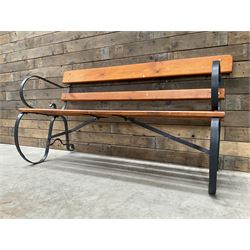 Wrought metal scrollwork and wood slatted garden bench