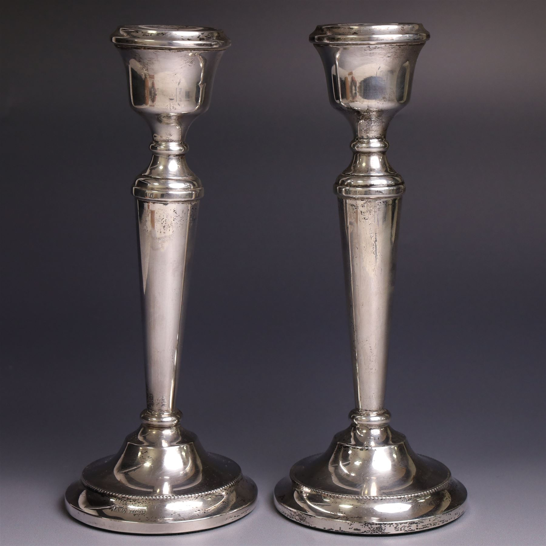 Pair of late 20th century silver candlesticks, each with tapering stem and upon circular beaded weigthed foot, hallmarked A T Cannon Ltd, Birmingham 1970, H21cm
