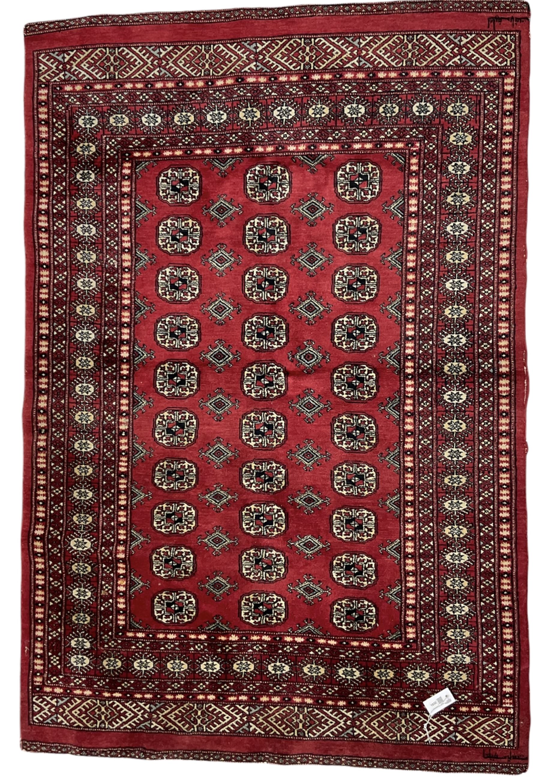 Turkmen Tekke Bokhara rug, red ground and decorated with Gul motifs, repeating multi-band border, signed on corners 