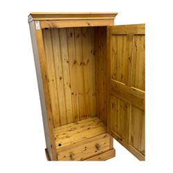 Pine single wardrobe, enclosed by single panelled door, fitted with single drawer, on plinth base 