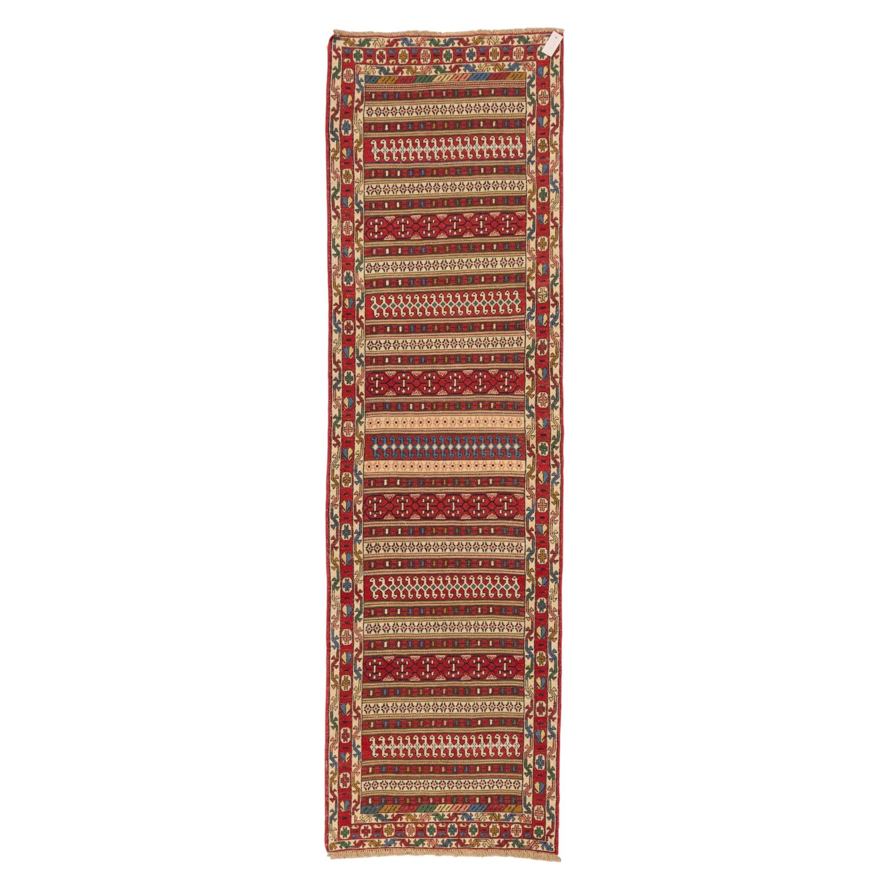 North East Persian Sumak flatweave kilim runner, elongated field decorated with horizontal bands of stylized geometric motifs in madder red, ivory, indigo green, and ochre enclosed by bold geometric borders  