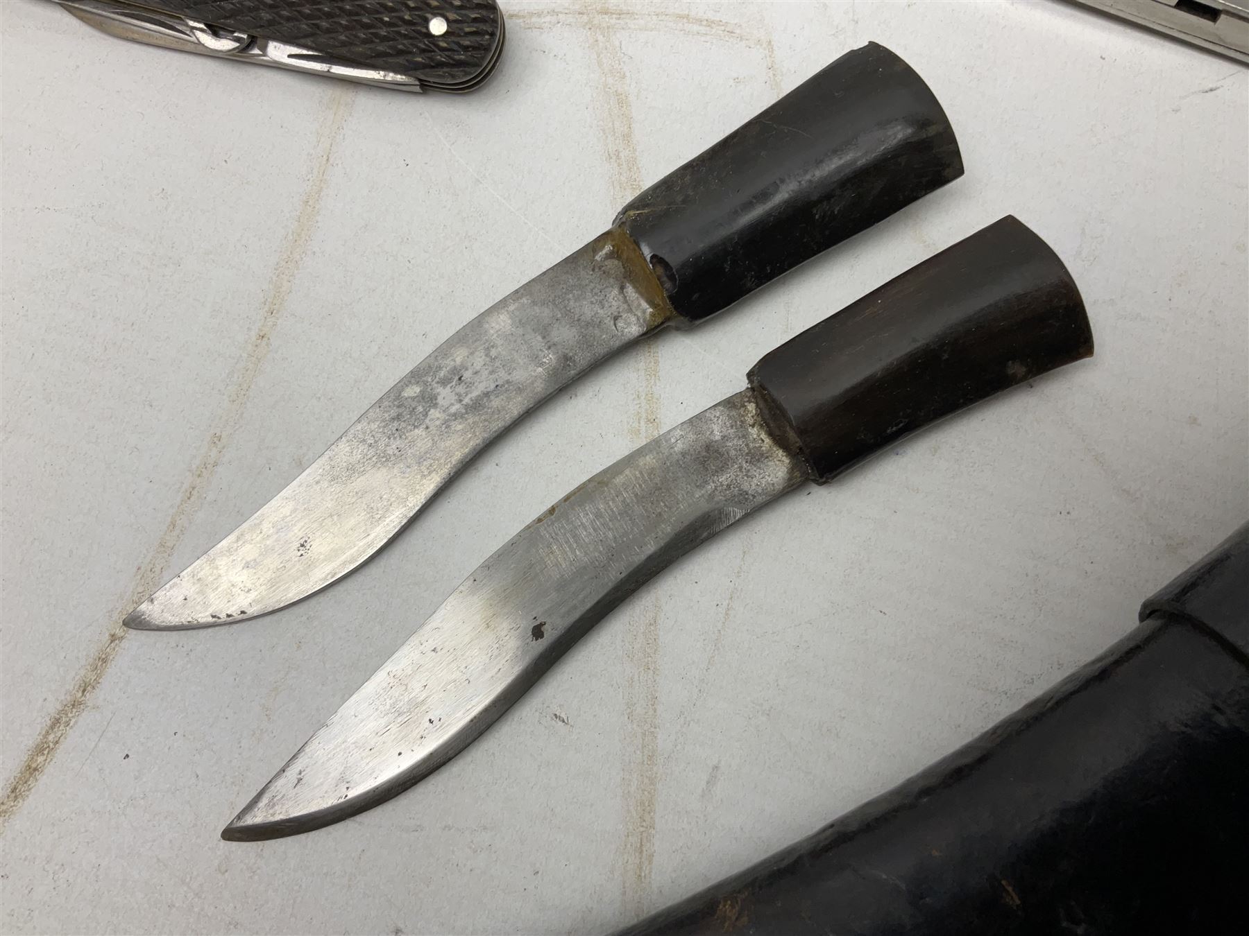 WW2 Gurkha Kukri knife with 34cm curving steel blade and horn handle; in leather covered scabbard with dual belt loops and two horn handled skinning knives L47cm overall; and collection of fourteen military and other folding and pocket knives including WW2 British Army clasp jacknife, J.H. Thompson C.C.1286 army knife dated 1954, Brookes & Crookes multiblade pocket knife etc (15)
