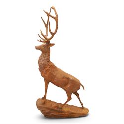 Pair of cast iron stags, upon a on moulded rocky plinth, standing alert 