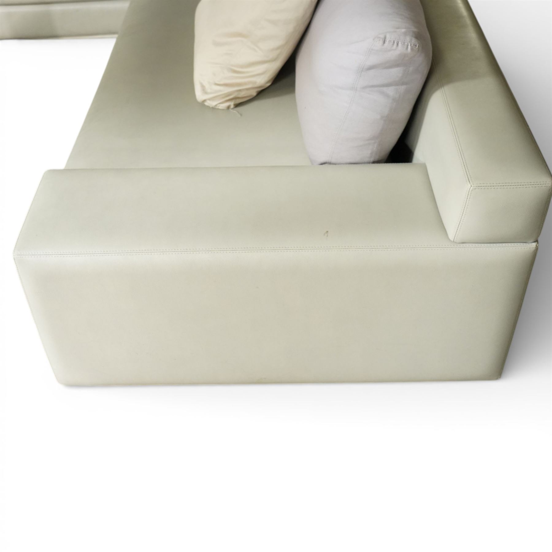 Christian Liaigre (1943-2020) - 'Arpege' handmade L-shaped sectional sofa, upholstered in neutral leather, with broad squared arms, deep seat cushions, angled chaise section, loose back cushions, raised on block feet