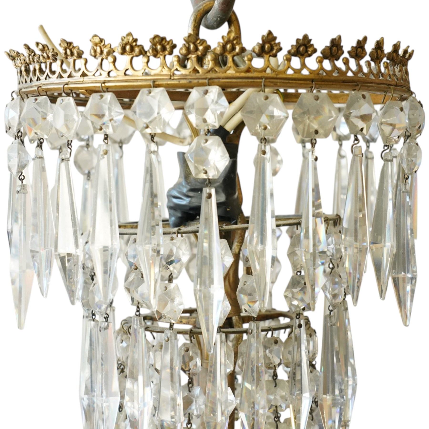 Regency Country House cut-glass and ormolu six light chandelier, the outer shaft with ormolu foliate moulding hung with octagonal and drop pendants, the impressive central shaft with cascading drops of cut-glass, the scroll branches with hob-nail cut candle holders and wax pans, with central similarly cut terminal
Provenance: property of a nobleman