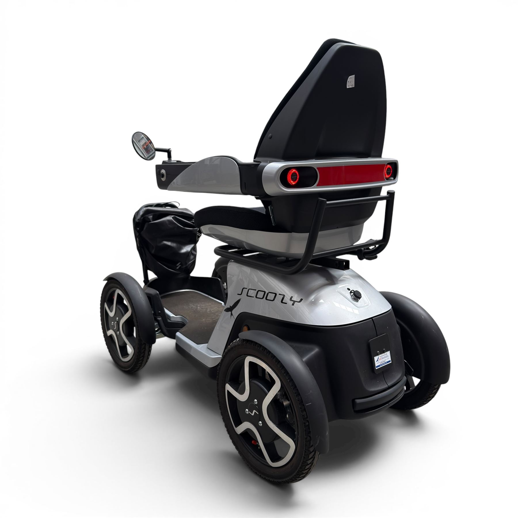 TGA Scoozy - mobility scooter, four wheel model with joystick controls, front storage bag, lights and grey and black bodywork.
