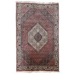 Persian Bidjar pale red ground rug, overlapping lozenge field decorated with Herati motifs, guarder border with trailing design decorated with stylised plant motifs