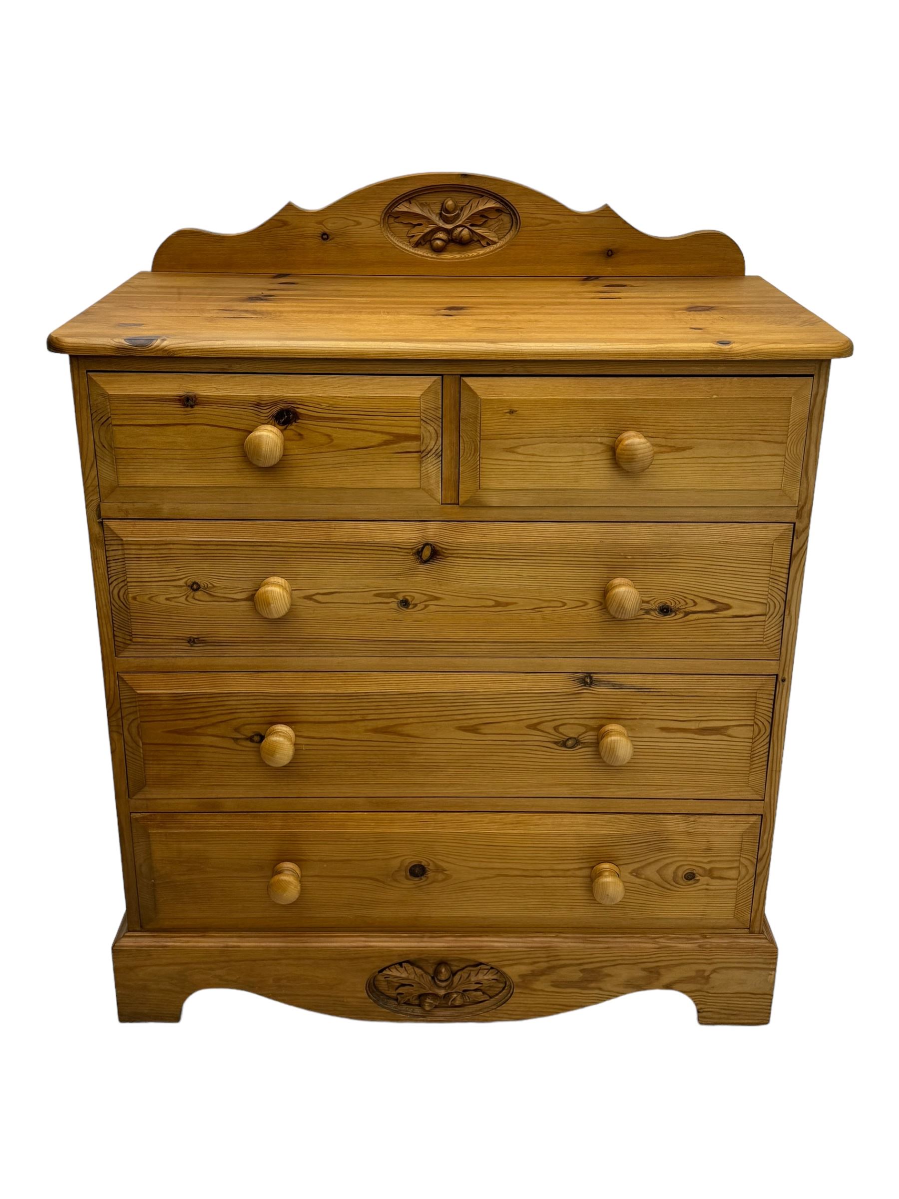 Pine chest of drawers topped with carved pediment with acorn and oak leaf motif, fitted with two short over three long drawers, standing on shaped apron base (W92, D46, H97cm); pine bedside cabinet, single drawer above paneled cupboard door enclosing open storage, shaped plinth base (W43, L32, H67cm)
