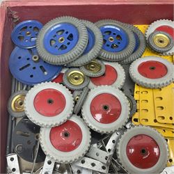 Meccano - quantity of loose sections in black, silver and yellow including various size flat and flanged plates, pulley and gear wheels and tyres, various size perforated strips, rods, spanners and crank handles, brackets, double angle and curved strips, various set instruction manuals etc; in wooden tray