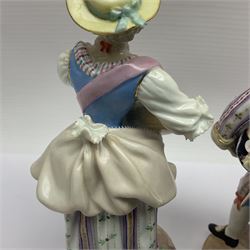 Pair of late 19th/early 20th Century Meissen figures, modelled as flower sellers, after the original by Michel Victor Acier, she holding basket of flowers, he holding flowers in his hat, each with underglaze cross swords mark beneath, tallest H16.5cm