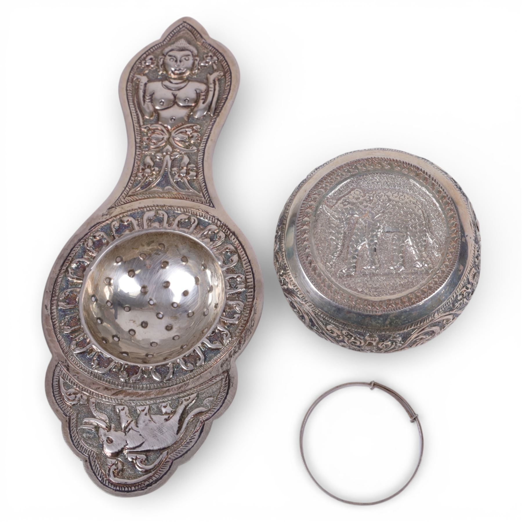 Sri Lankan silver tea strainer and bowl, embossed with elephant decoration and a silver child's bangle