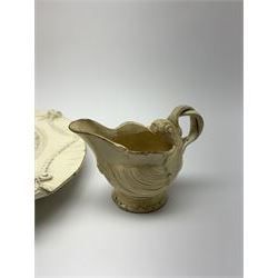 Small 18th century Leeds Pottery silver shape cream boat, with reeded entwined handle, L9cm, H7cm, together with a late 18th/early 19th century creamware stand or dish, of oval form detailed with feathered edge, husk swags and two masks, L28.5cm. 