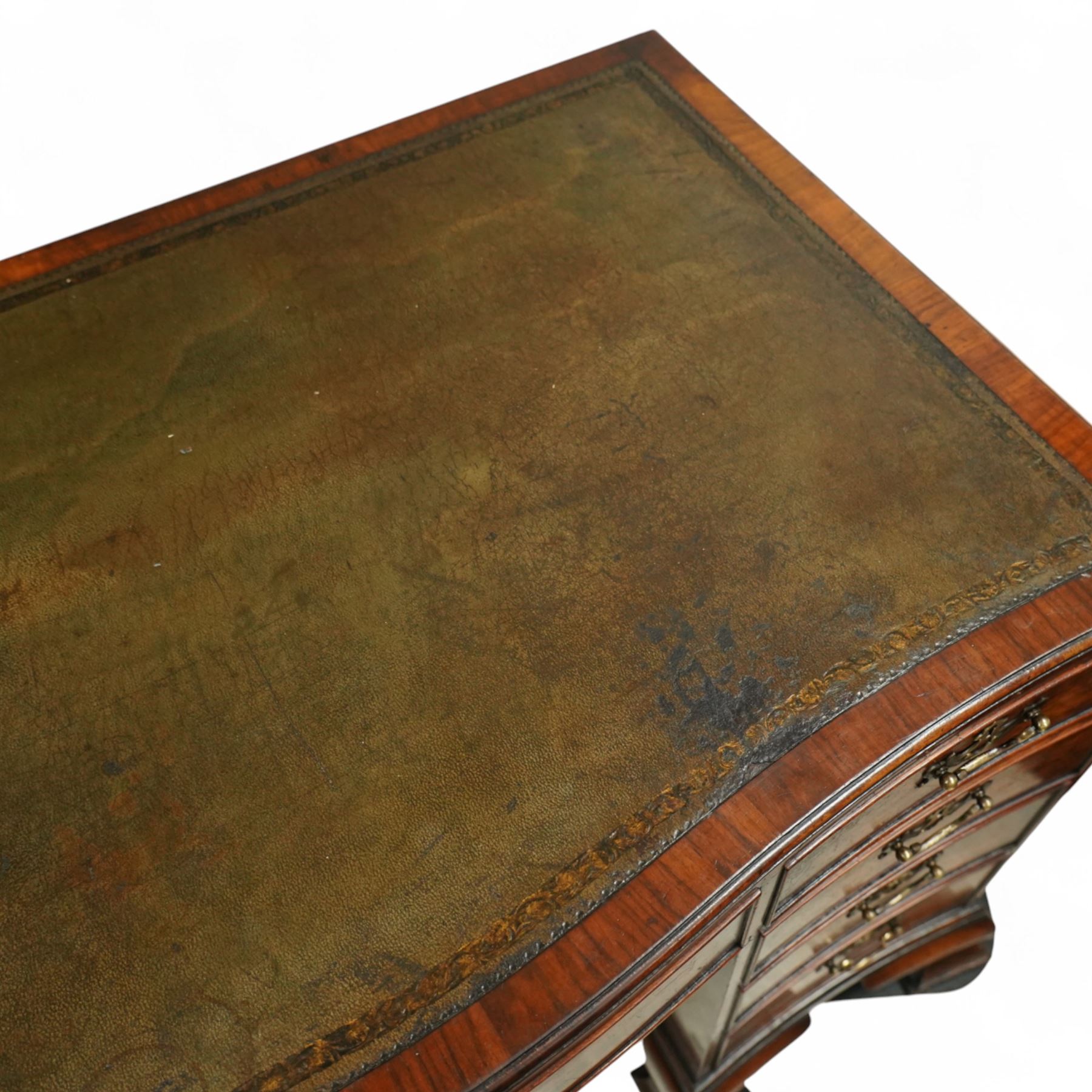 Early 20th century inlaid mahogany pedestal kneehole desk, rectangular top with inset tooled leather writing surface, over an arrangement of nine drawers with brass swan neck handles, on ogee bracket feet