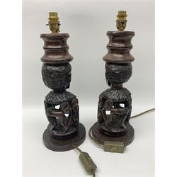 Pair of 20th century carved wood table lamp with African busts and figures, together with a carved wooden figure and soapstone figure, lamps H44cm