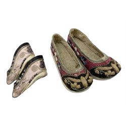 Two pairs of late 19th/early 20th century Chinese Lotus shoes for binding feet, the first with purple silk heavily embroidered with ornate floral motifs, L10cm the second larger fuschia and black pair with thicker sole embroidered with flowers, L14cm