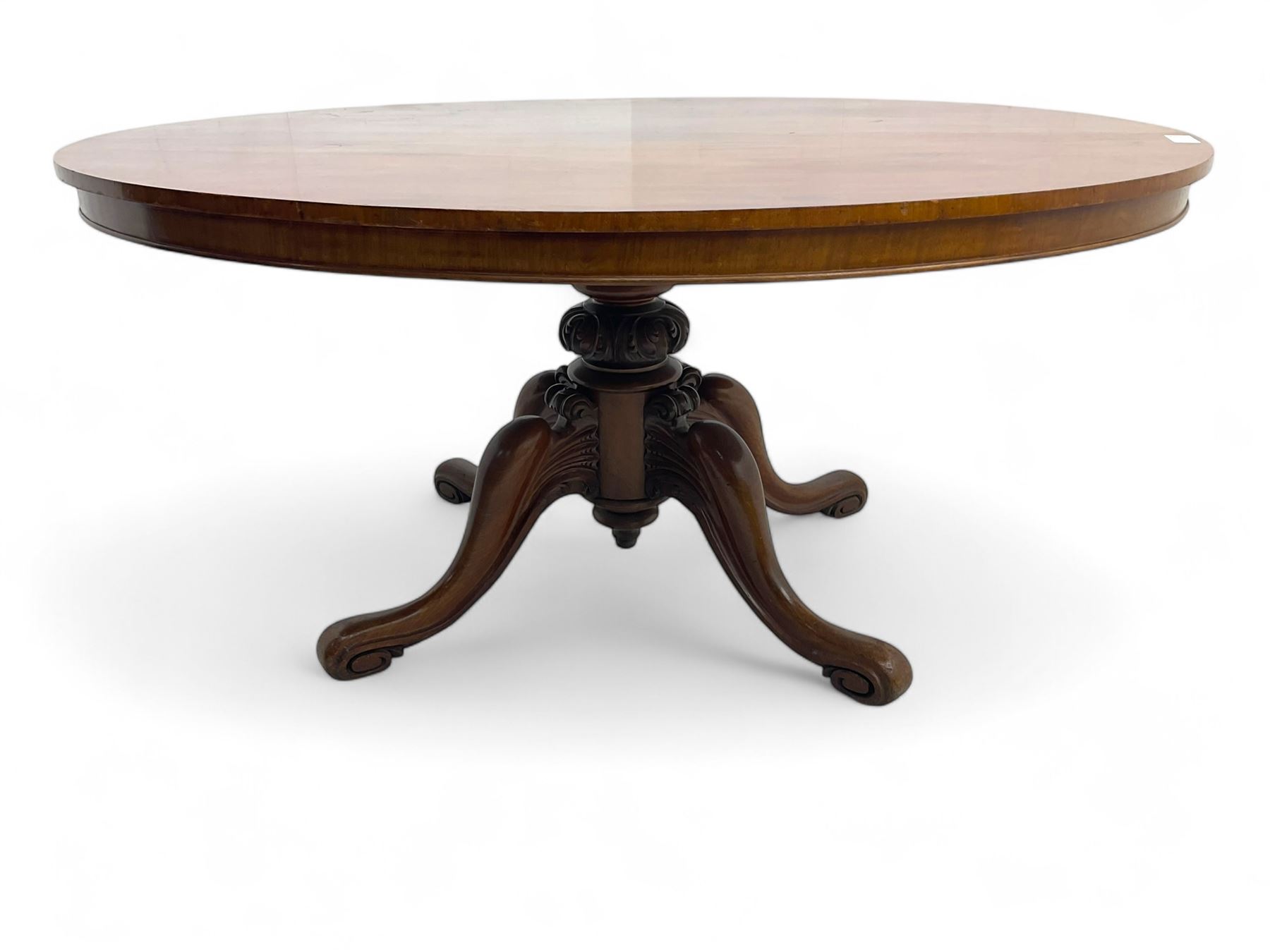 Victorian mahogany breakfast loo table, oval tilt-top on turned pedestal, quatrefoil out-splayed carved supports, scroll carved terminals with brass castors