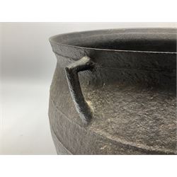 Late 17th century cast iron cauldron, of bellied form with girdle bands and twin angular handles, upon tripod feet, H26.5cm rim D33cm