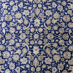 Central Persian Kashan hand-knotted rug, deep blue all-over field, finely decorated with dense scrolling floral sprays, palmettes, and flowering vines in ivory, soft gold, and pale green tones, enclosed by a multi-band floral border with corresponding guard stripes, with cotton fringe ends, signed Shah Abassi Workshop 