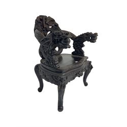Japanese Meiji period open armchair, the back carved and pierced with dragon and scrolling scaled tails, projecting dragon carved arm terminals on scrolled supports, serpentine seat with decorative band, the apron and supports with scroll and chip-carved decoration
