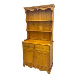 Victorian design pine dresser, projecting moulded cornice over scalloped frieze and two open shelves, base fitted with two drawers over double cupboard, on shaped plinth base
