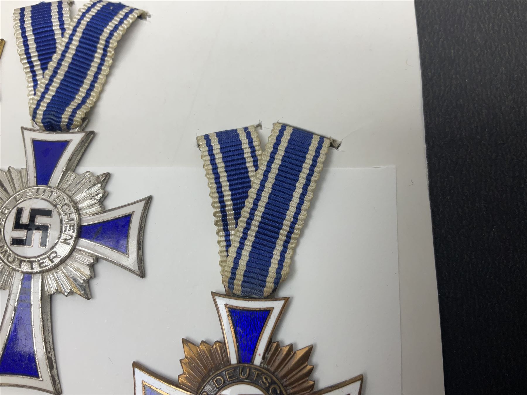 WWII set of three German Mother's Crosses, 1st Class in gilt, 2nd Class in silver and 3rd Class in bronze; all with ribbons (3)