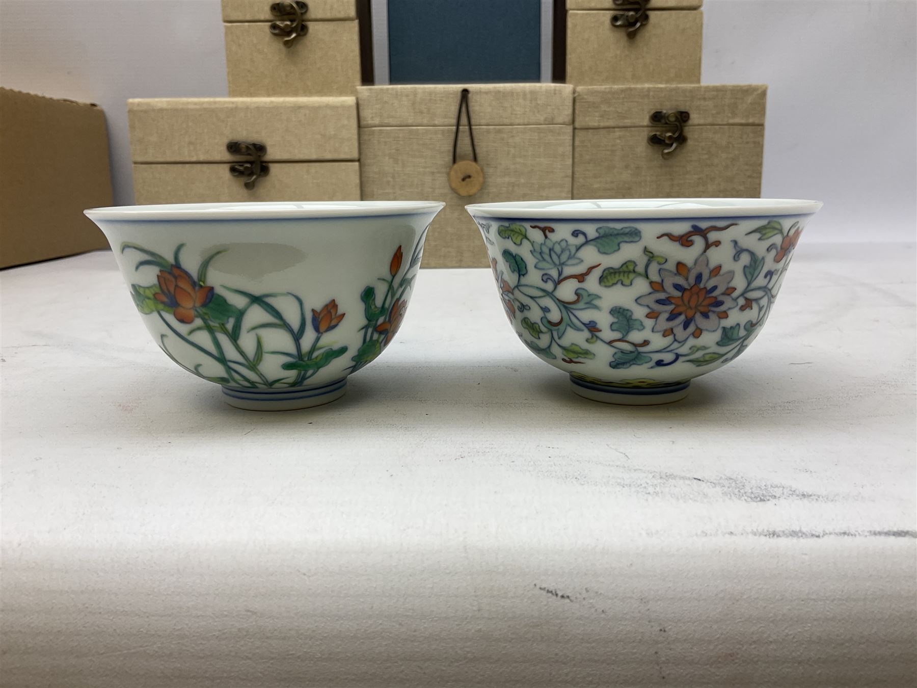 Two Chinese Yixing teapots, Chinese tea bowl hand painted with figures reading, another tea bowl with with underglaze floral panel and another tea bowl with saucer and lid, together with other teacups etc all boxed and with character marks