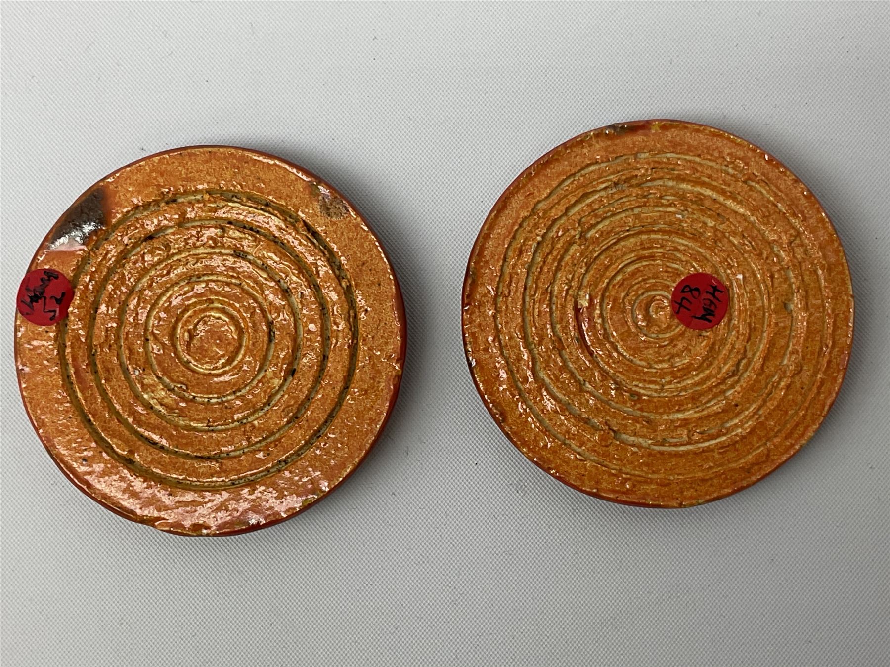 Henry George Murphy (1884-1939), collection of seven Arts & Crafts glazed ceramic roundels, of circular and oval form, five in tones of red and brown and two in tones of blue, turquoise and green in soufflé and high fired finishes, largest example D6.5cm