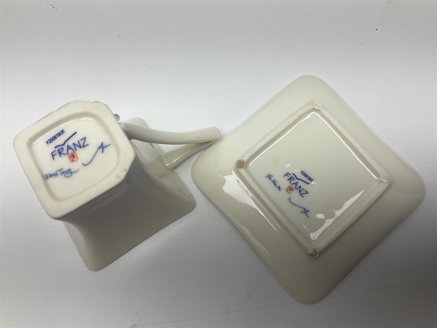 Franz Teapot decorated with dragonflies, together with a matching sucrier and cover and a cup and saucer in Iris pattern, all with printed mark beneath 