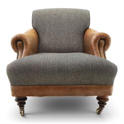 Tetrad - 'Taransay' Harris Tweed and tan leather club armchair, Howard shape with reclined back over deep seat and rolled arms with studwork, raised on turned front supports with castors, the sides and arms upholstered in tan leather with seat and back in herringbone-stitched Harris Tweed