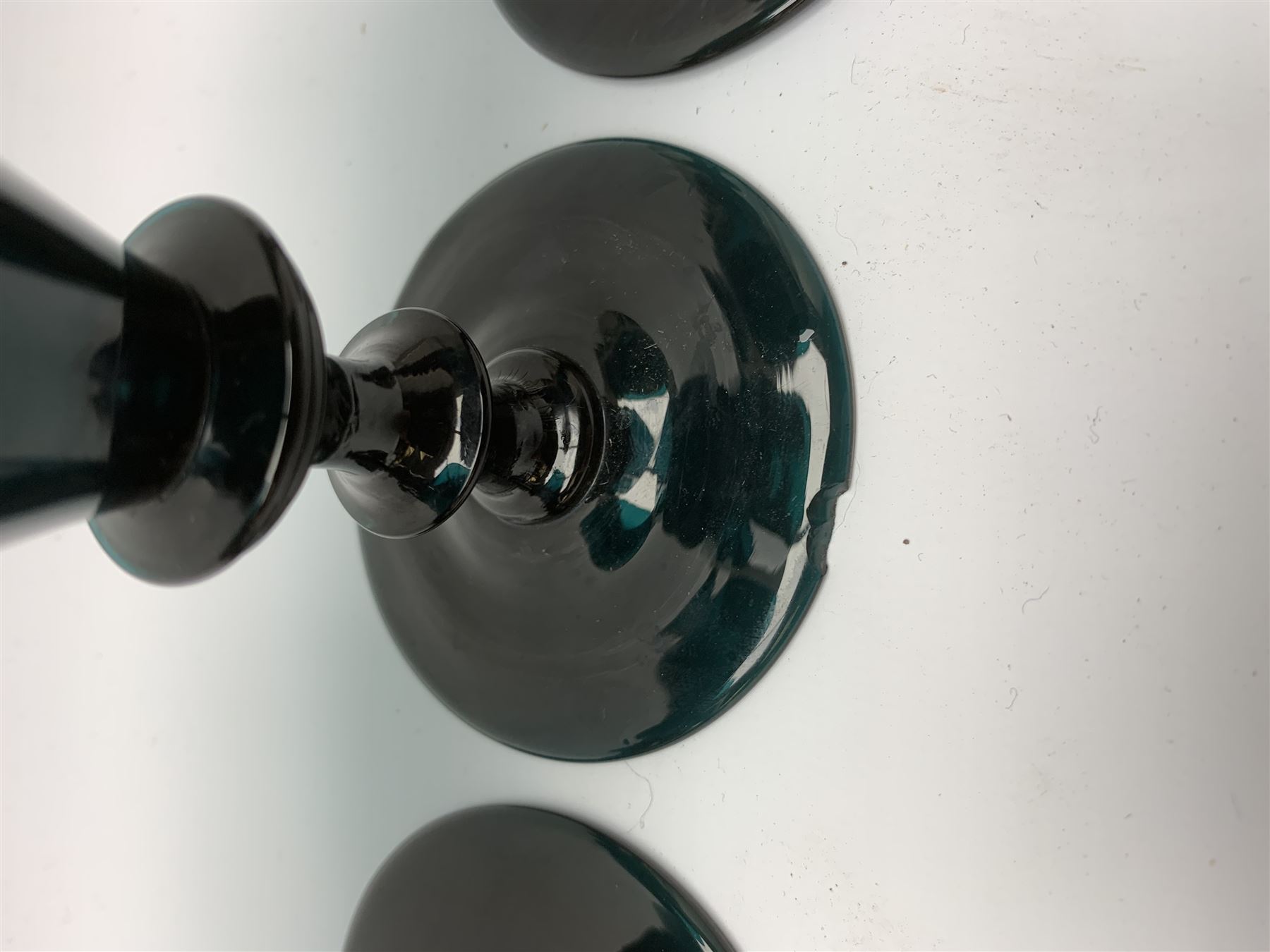 19th century green glass ships decanter with flat topped stopper, H21.5cm, together with a set of four 19th century green glass wine glasses, the funnel bowls upon bladed knopped stems and circular feet, H13cm