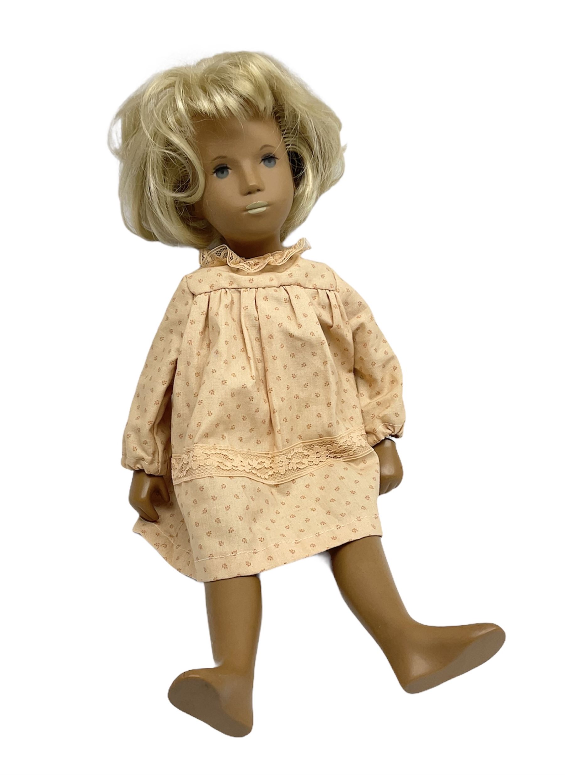 Sasha Morgenthaler vinyl doll, the girl's head with painted blue eyes and lips and short blonde hair, the jointed body donning a peach floral dress with matching underclothes, unmarked, H41cm