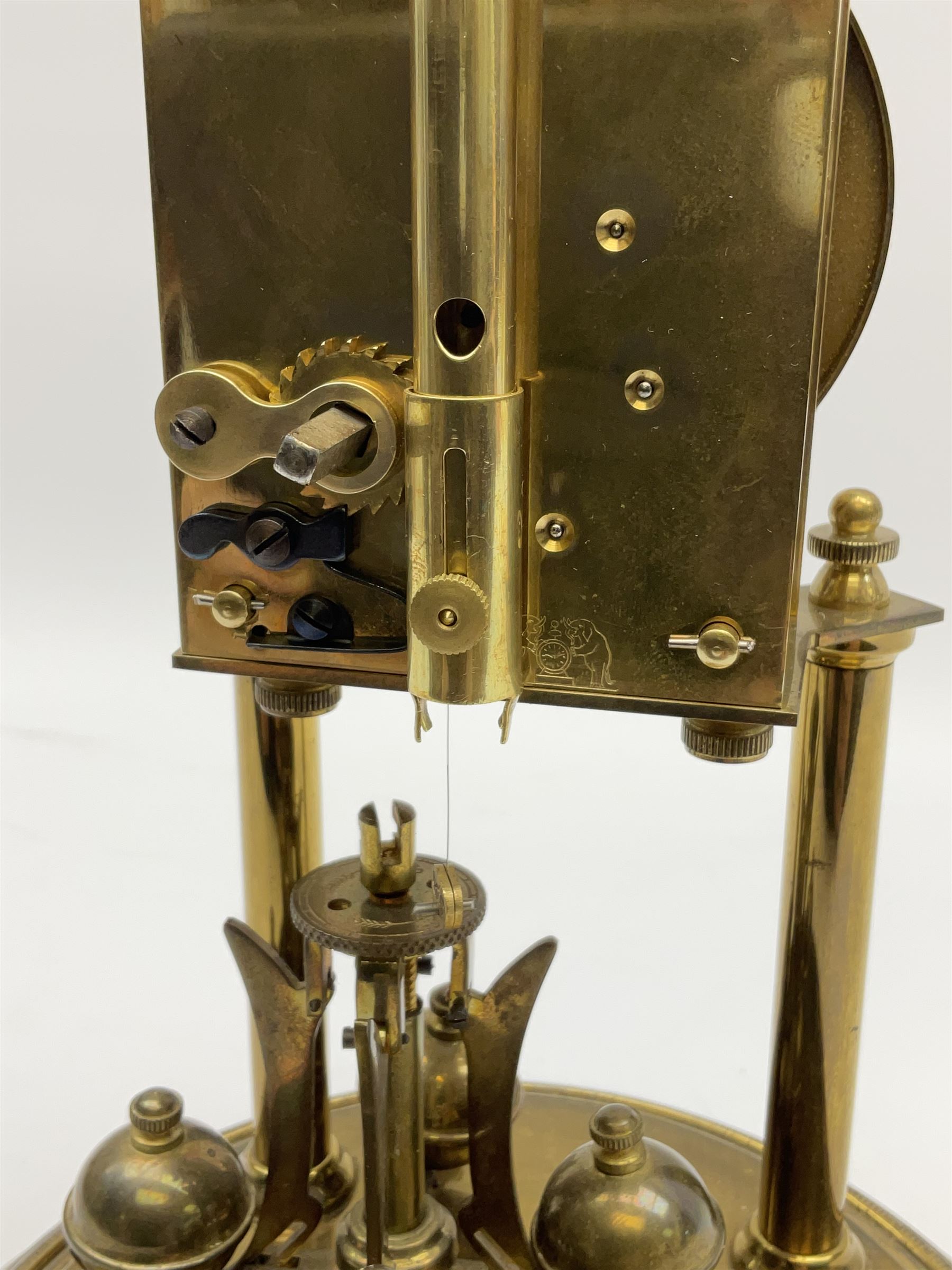 A German torsion pendulum clock by  Jahresuhrenfabrik (August Schatz & Söhne), Triberg, Germany, early 20th century with a 2-3/4-inch cream enamel dial within a spun bezel, upright Arabic numerals with minute track and steel spade hands, 400-day spring driven movement with a four-ball rotary pendulum, clear glass dome on a  20cm circular brass effect base.
Height 32cm 
