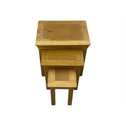 Contemporary light oak nest of three tables, each with rectangular top with moulded edge, raised on square supports