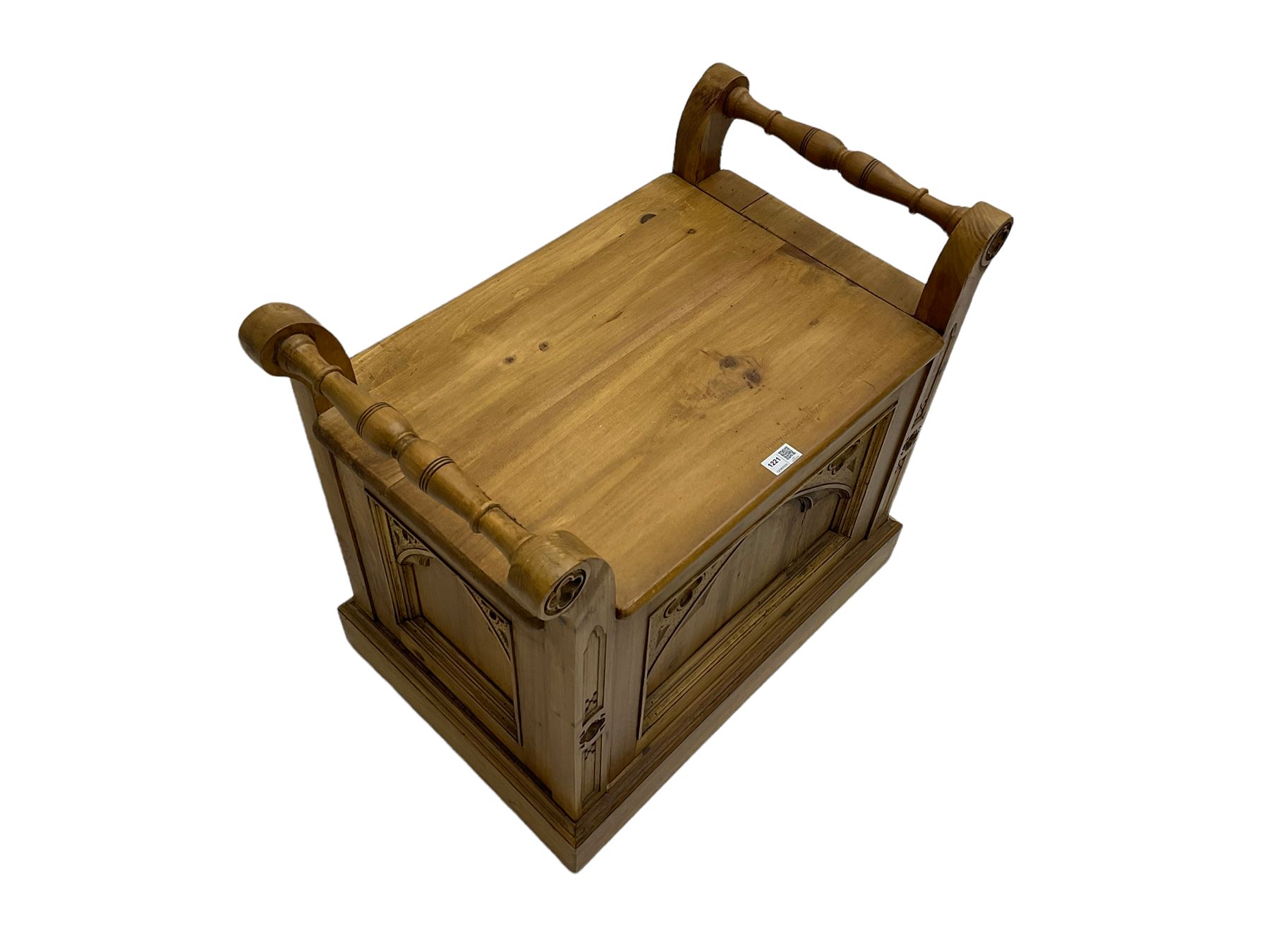 Gothic style pine stool with hinged box seat, decorated with flower head motifs, plinth base