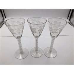 Set of three 18th century style wine glasses, each with funnel bowl etched with fruit vine, upon a double series air twist stem and circular foot, H17cm