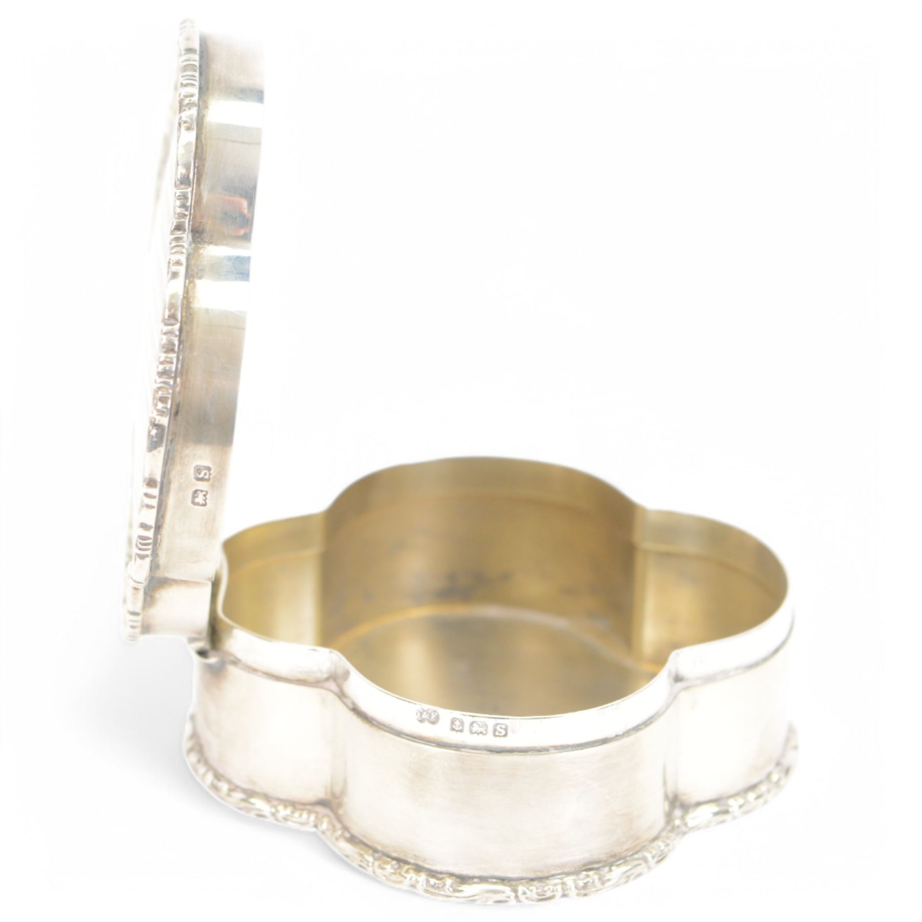 Early 20th century silver trinket box, of quatrefoil form, with shaped rim and engine turned decoration to cover, with vacant circular cartouche, hallmarked Deakin & Francis, Birmingham 1917 or 1942, H3cm, W8.5cm, together with an early 20th century silver swing handled sugar basket, with gilt interior, hallmarked Levi & Salaman, Birmingham 1918