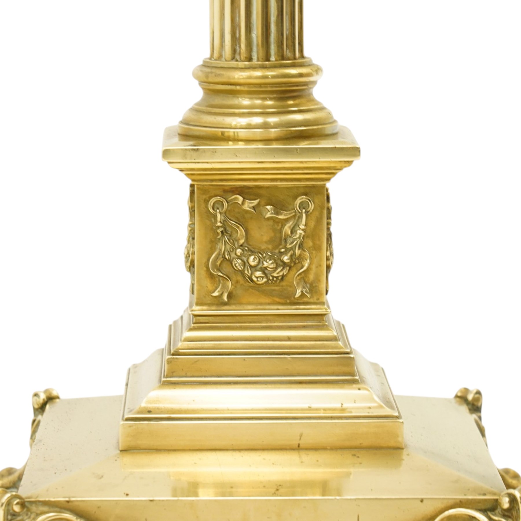 Late Victorian Neoclassical brass standard lamp with shade, the composite Ionic and Corinthian acanthus capital over a reeded column, terminating to a stepped platform base with applied festoon ornament, raised on four scrolling ball-and-claw feet