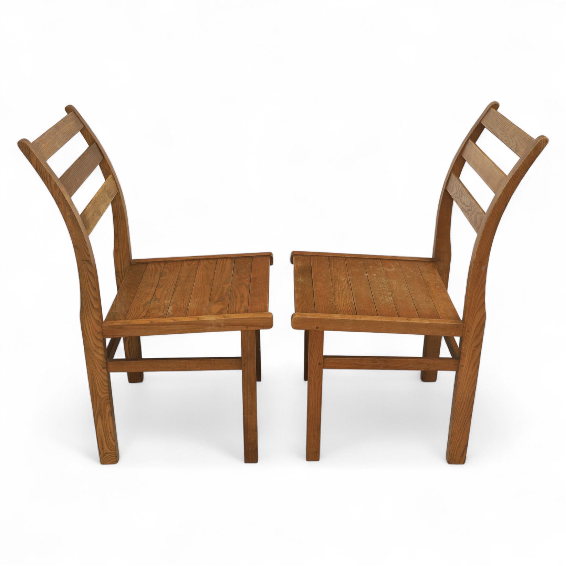 Treske of Thirsk - solid oak refectory dining suite, rectangular top with chamfered edge over trestle base united by a central stretcher, together with six matching slat back dining chairs, including two carvers, with panelled seats and square legs united by stretchers (H 87cm, W 62cm, D 57cm)