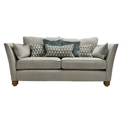  Oak Furnitureland - 'Gainsborough' lounge suite - three seat sofa, out-swept arms with loose cushions on turned oak feet, upholstered in 'Minerva Silver' fabric (W209cm D102cm H80cm); matching armchair or snuggler settee (W125cm); and rectangular ottoman footstool