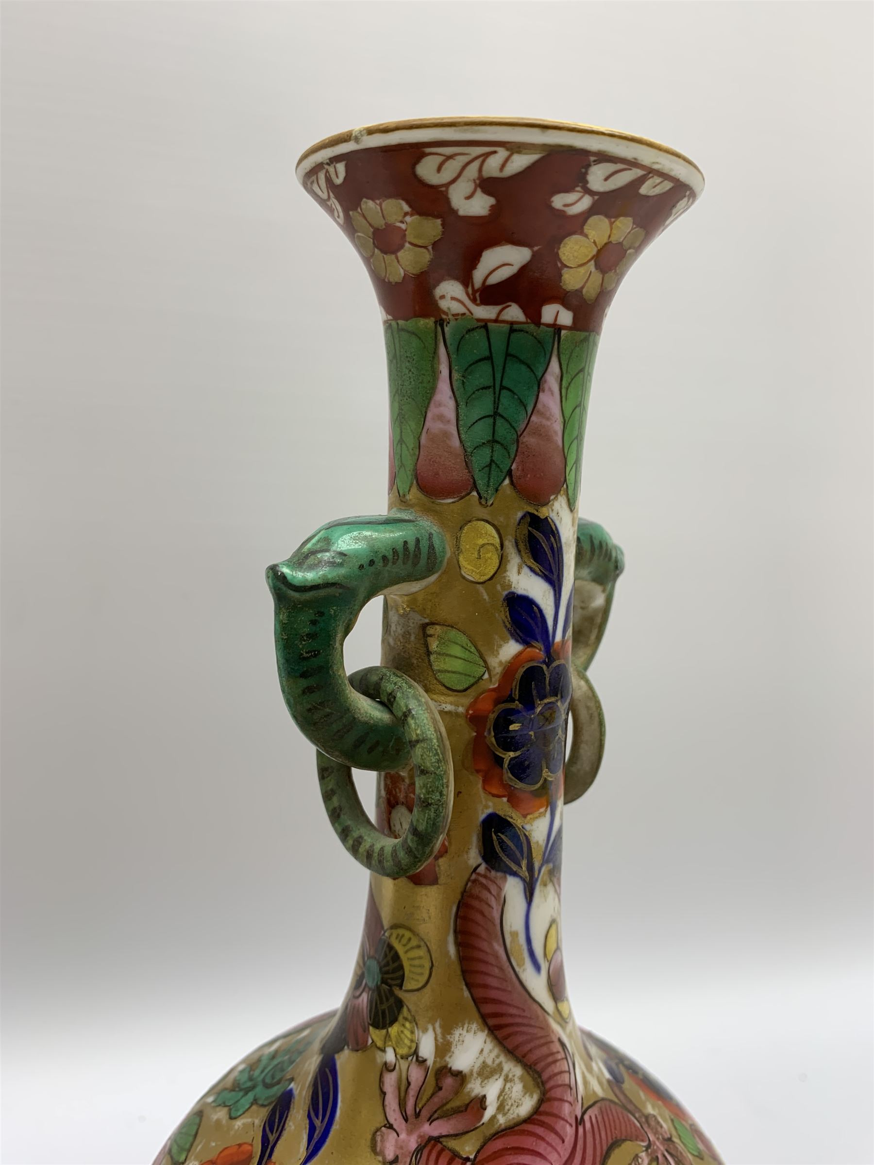 Pair of early 19th century Miles Mason vases, the baluster bodies with tall slender necks supporting twin stylised trunk handles with rings, decorated with Chinese dragons, butterflies, and blossoming flowers against a gilt ground, with spurious Chinese marks beneath in iron red, H27.5cm