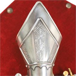 Three replica gauntlets, each housed upon a red wall shield, two with daggers, the third with a sword, largest H102cm