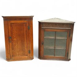 Georgian oak corner cupboard together with a later example, the first with plain panel doo...