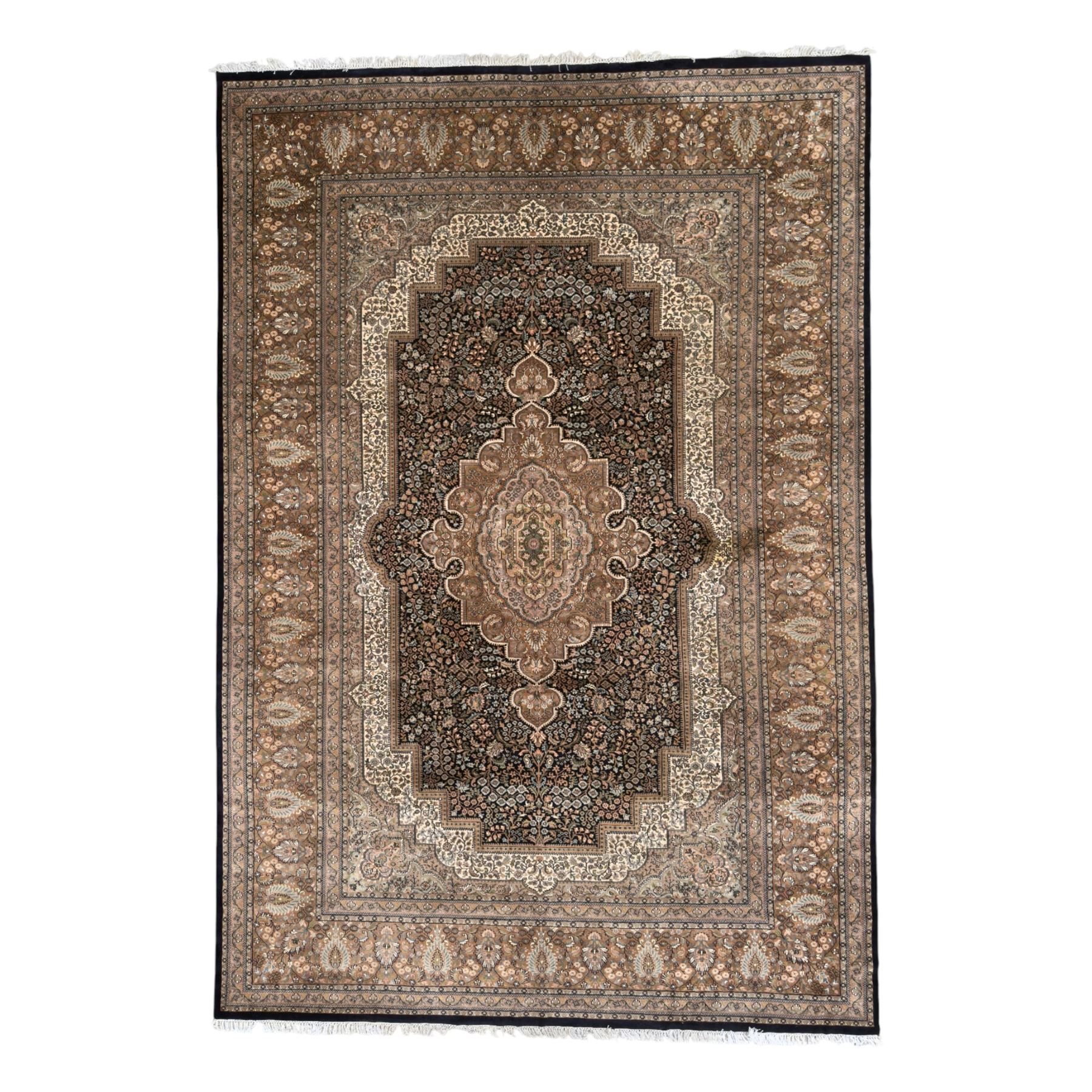 Large Persian indigo ground rug, the busy field decorated with trailing branches and flower heads, peach border decorated with palmettes -