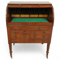 Regency period mahogany cylinder desk, the roll-top enclosing a fitted satinwood interior with pigeonholes and drawers, sliding green baize writing surface, lower section fitted with four drawers and a cupboard, on reeded tapering legs with brass caps and castors