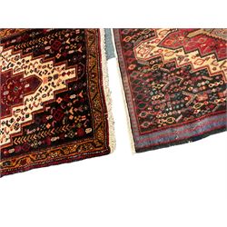 Small Hamadan dark indigo ground rug, central ivory and maroon lozenge with geometric decoration, guarded border with repeating stylised plant motifs, together with three others (4)