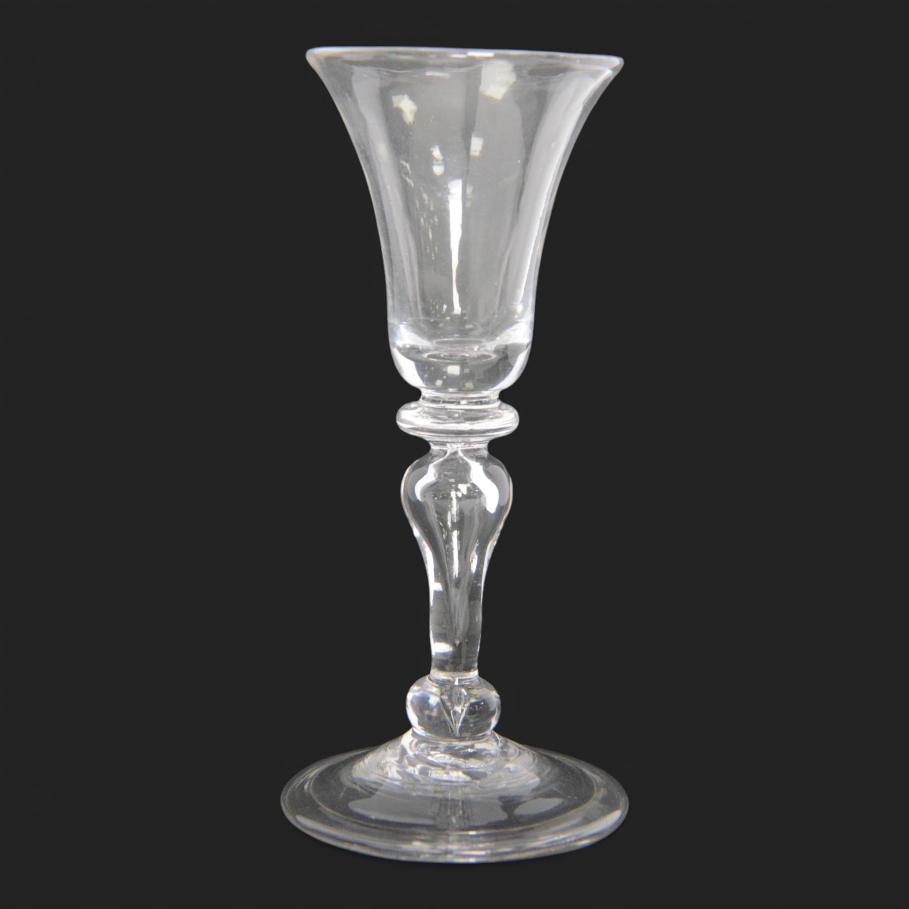 Mid 18th century wine glass, circa 1730-1740, with bell shaped bowl upon an inverted baluster stem with internal tear and basal knop, upon conical folded foot, H15cm