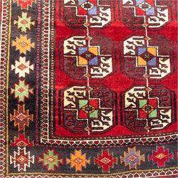 Tekke Bohara hand-knotted rug, madder red field decorated with an all-over design of repeating octagonal guls and latch-hook motifs within multiple geometric borders and cotton fringe ends 