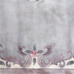 Chinese Aubusson-style jade green wool rug, with a floral medallion and floral corner sprays with a scrolling acanthus and ribbon border in tones of teal, cream, pink, mauve, and cotton fringe ends